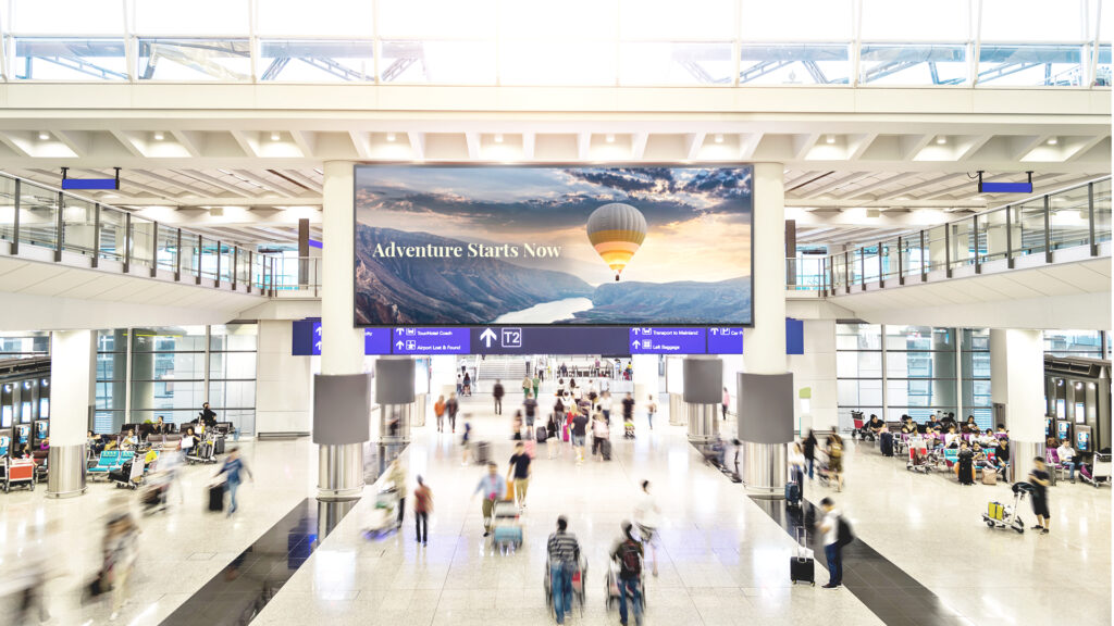 Blurred people and blank billboard in airport